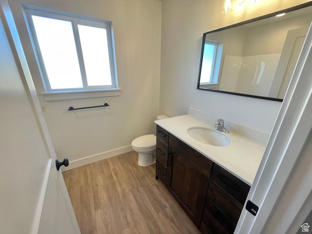 884 W Factory St, Garland, UT 84312 - bathroom featuring baseboards, wood finished floors, toilet, and vanity