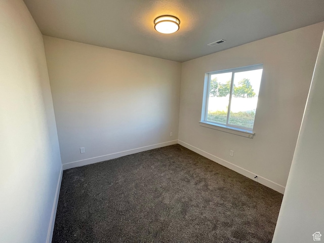 884 W Factory St, Garland, UT 84312 - empty room with dark carpet, visible vents, and baseboards