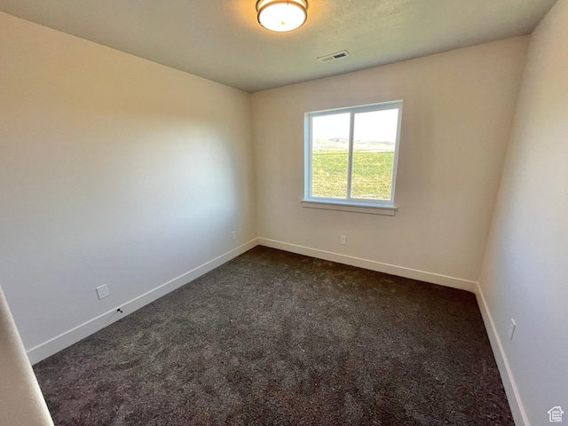 884 W Factory St, Garland, UT 84312 - unfurnished room featuring dark carpet, visible vents, and baseboards