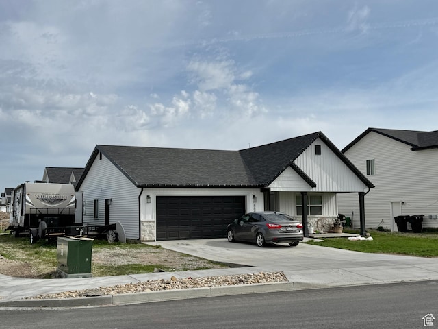 884 W Factory St, Garland, UT 84312 - view of front of property with concrete driveway, an attached garage, board and batten siding, and roof with shingles