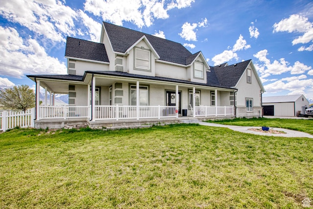farmhouse with covered porch, an outdoor fire pit, a front lawn, and stucco siding