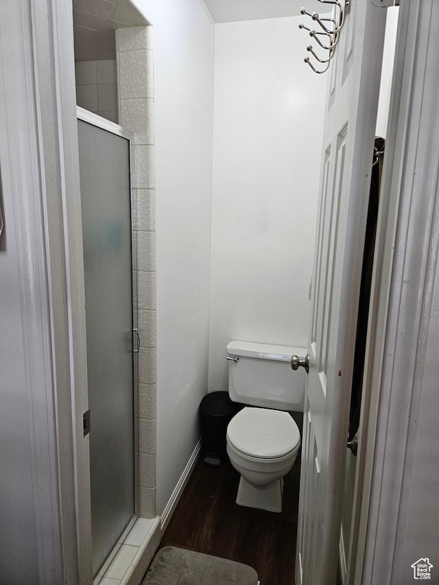 1381 W Beacon Hill Dr S, Taylorsville, UT 84123 - bathroom featuring wood finished floors, a shower stall, toilet, and baseboards