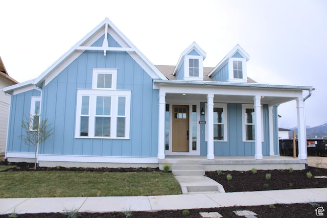 modern inspired farmhouse with a front yard, board and batten siding, and a porch