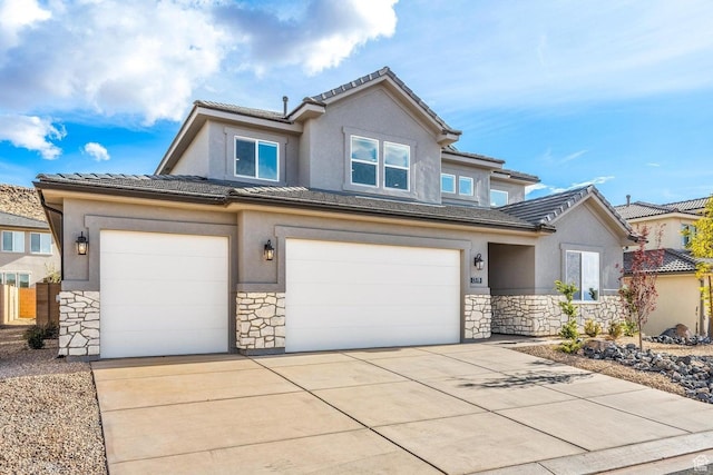 view of front of house featuring stone siding, an attached garage, and stucco siding