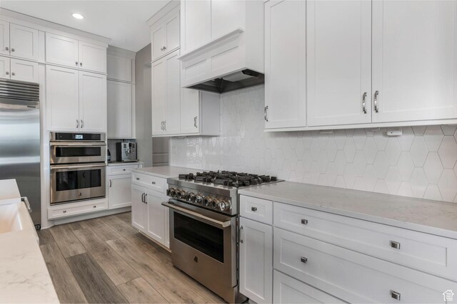 4772 W Thorntree Ln, Herriman, UT 84096 - kitchen with white cabinets, high end appliances, custom exhaust hood, and decorative backsplash