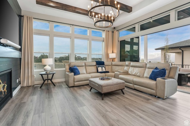 4772 W Thorntree Ln, Herriman, UT 84096 - living room featuring wood finished floors, beamed ceiling, a large fireplace, baseboards, and a notable chandelier