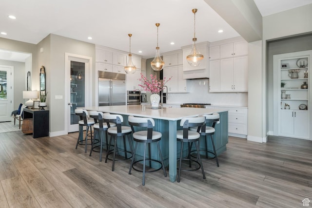 4772 W Thorntree Ln, Herriman, UT 84096 - kitchen featuring recessed lighting, stainless steel built in fridge, light countertops, light wood finished floors, and white cabinetry