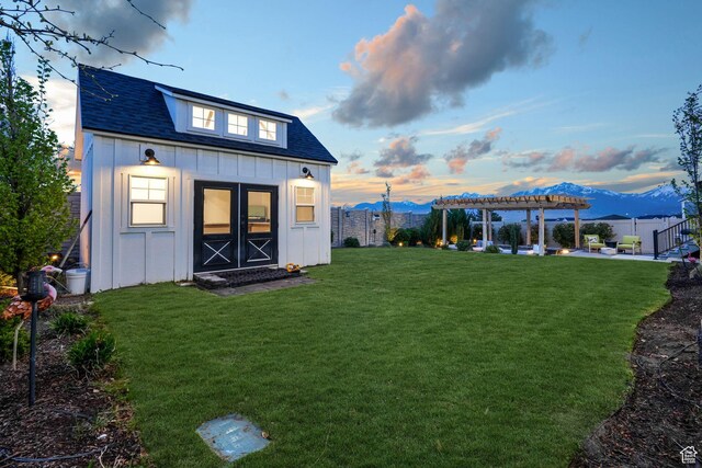 4772 W Thorntree Ln, Herriman, UT 84096 - back of house at dusk featuring a pergola, a fenced backyard, board and batten siding, and a mountain view