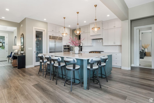 4772 W Thorntree Ln, Herriman, UT 84096 - kitchen with light wood-style flooring, recessed lighting, white cabinets, and appliances with stainless steel finishes