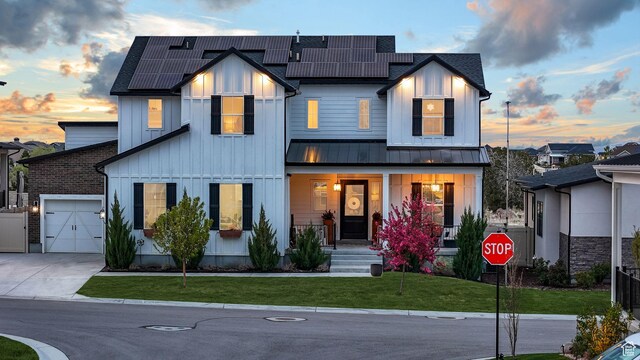 4772 W Thorntree Ln, Herriman, UT 84096 - modern inspired farmhouse featuring a porch, a standing seam roof, a lawn, driveway, and an attached garage