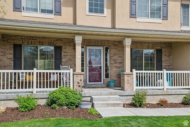 1030 S Barley Ln, Kaysville, UT 84037 - view of exterior entry with covered porch, brick siding, and stucco siding