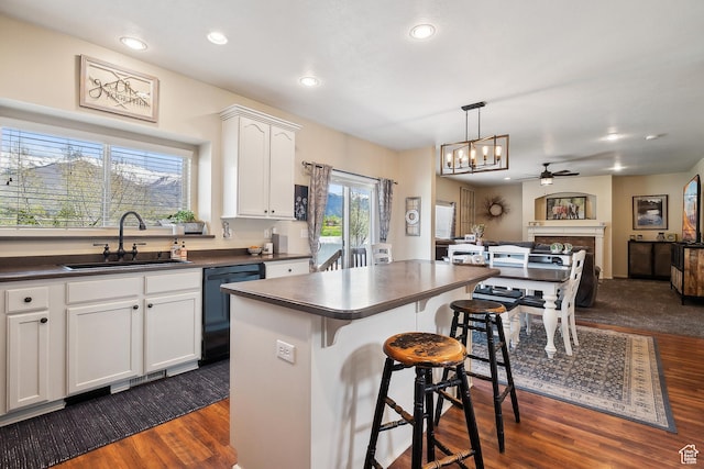 1030 S Barley Ln, Kaysville, UT 84037 - kitchen featuring a sink, dark wood-style flooring, a kitchen breakfast bar, dark countertops, and dishwasher