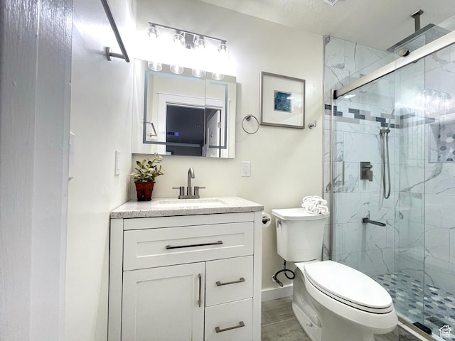 full bathroom with baseboards, a shower stall, toilet, and vanity