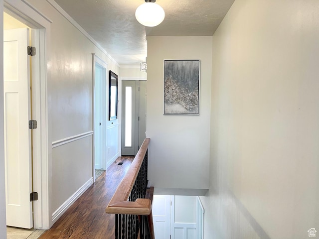 hallway with baseboards, wood finished floors, and crown molding