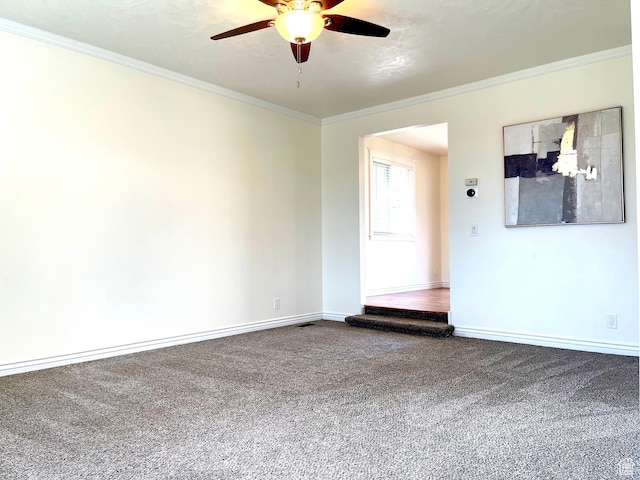 carpeted spare room with baseboards, ornamental molding, and ceiling fan