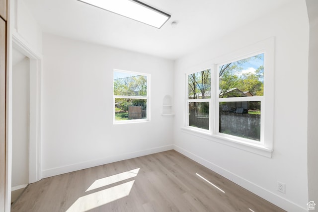 empty room with baseboards and light wood-style flooring