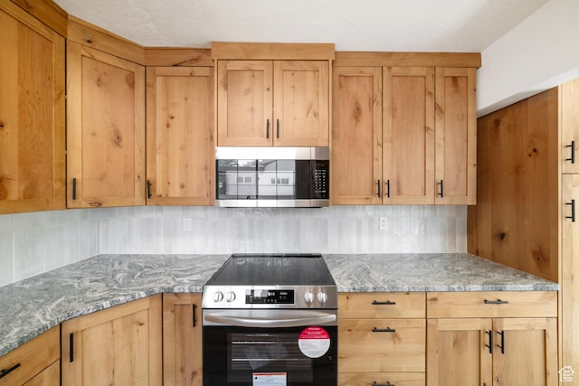 kitchen featuring light brown cabinetry, tasteful backsplash, stainless steel appliances, and light stone counters