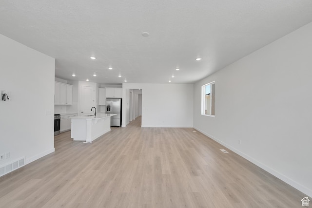 4099 W 2025 S Unit 51, Taylor, UT 84401 - unfurnished living room featuring recessed lighting and light wood finished floors