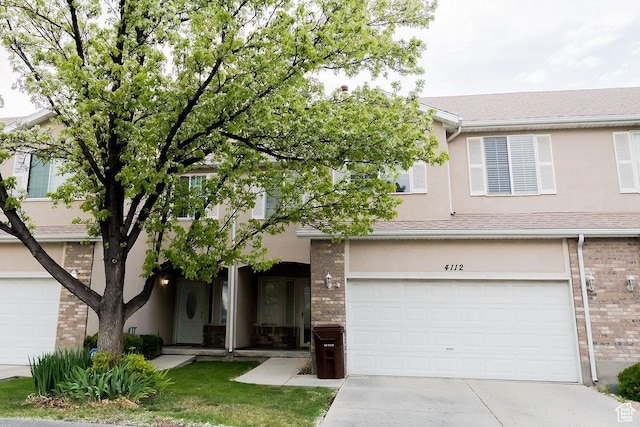 4112 W 4645 S, West Valley City, UT 84120 - view of front of home with concrete driveway, a garage, stucco siding, and brick siding