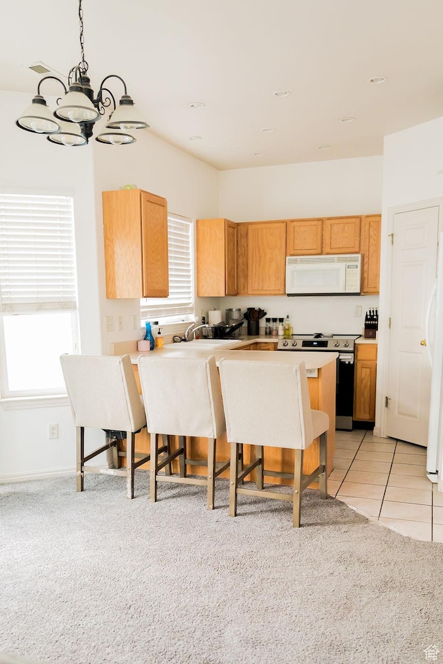 4112 W 4645 S, West Valley City, UT 84120 - kitchen featuring white appliances, a chandelier, a breakfast bar area, a wealth of natural light, and a peninsula