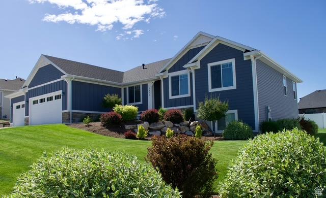 1076 E 300 S, Smithfield, UT 84335 - ranch-style home with board and batten siding, an attached garage, and a front yard