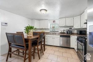 2959 S 9200 W, Magna, UT 84044 - kitchen with appliances with stainless steel finishes, light tile patterned flooring, white cabinets, and a sink