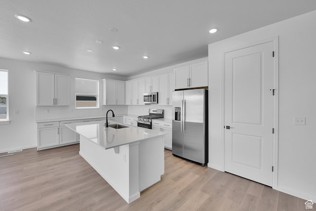 2074 S 3940 W Unit 11, Taylor, UT 84401 - kitchen featuring appliances with stainless steel finishes, white cabinetry, light wood-type flooring, recessed lighting, and a center island with sink