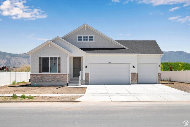 2074 S 3940 W Unit 11, Taylor, UT 84401 - view of front of home with stone siding, an attached garage, a mountain view, and concrete driveway