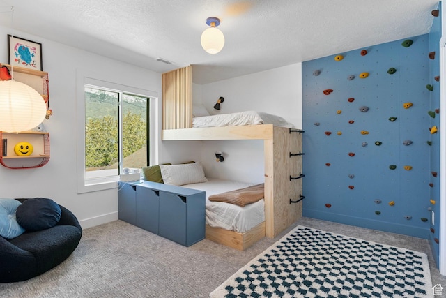 bedroom featuring a textured ceiling, carpet flooring, and baseboards