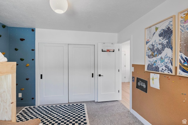 carpeted bedroom with baseboards and a closet