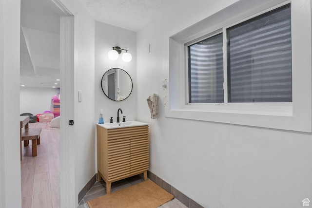 bathroom with baseboards, wood finished floors, and vanity