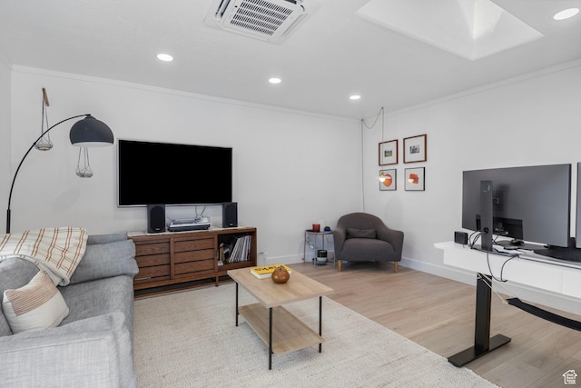 living area with recessed lighting, wood finished floors, baseboards, visible vents, and crown molding
