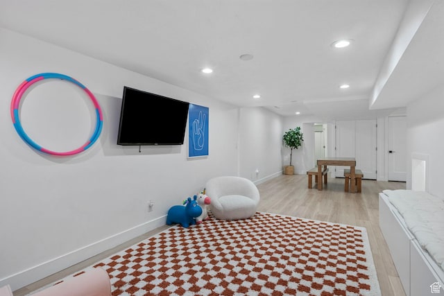 workout area featuring baseboards, recessed lighting, and light wood finished floors