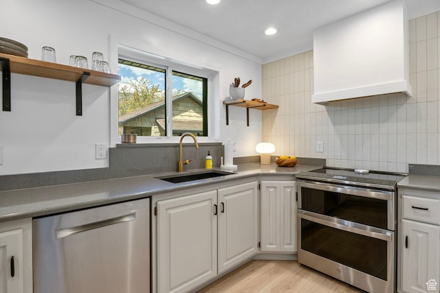 kitchen featuring light wood-style flooring, open shelves, appliances with stainless steel finishes, a sink, and white cabinetry