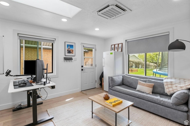 living room with visible vents, a skylight, a wealth of natural light, and recessed lighting