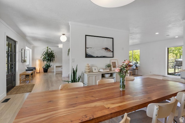 dining area featuring baseboards, visible vents, and light wood-style floors