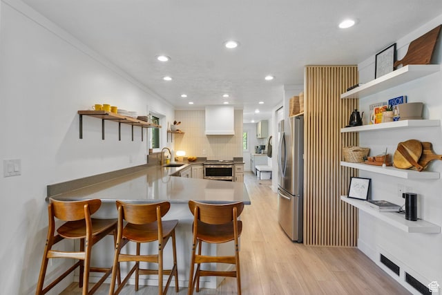kitchen with stainless steel appliances, open shelves, recessed lighting, and a sink