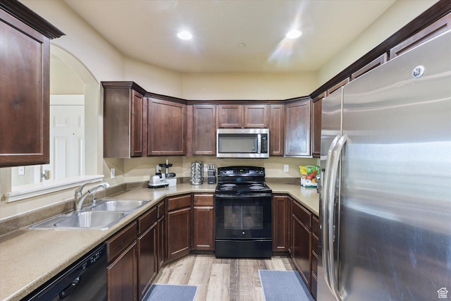 2153 N Springtime Dr, Saratoga Springs, UT 84045 - kitchen with a sink, dark brown cabinets, light countertops, black appliances, and light wood finished floors