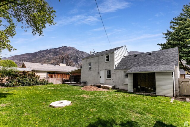 263 N 100 E, Springville, UT 84663 - back of house featuring a yard, brick siding, fence, a shingled roof, and a mountain view