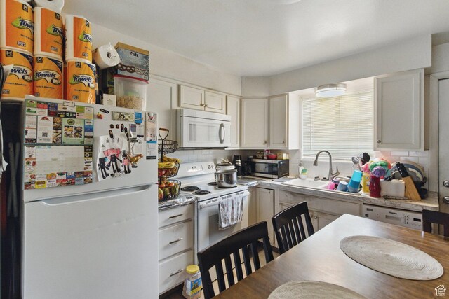 985 S 600 W, Provo, UT 84601 - kitchen featuring white appliances, decorative backsplash, light countertops, white cabinets, and a sink
