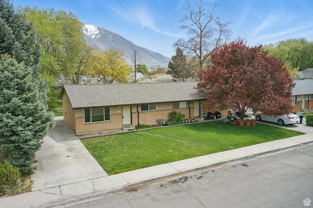 985 S 600 W, Provo, UT 84601 - ranch-style house featuring concrete driveway, a shingled roof, a front yard, a mountain view, and brick siding