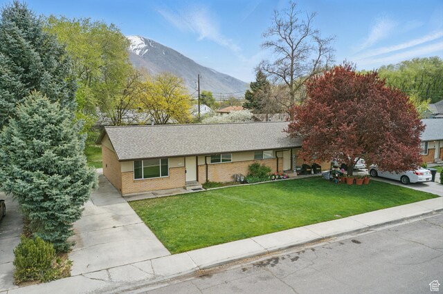 985 S 600 W, Provo, UT 84601 - single story home featuring a front yard, brick siding, a mountain view, driveway, and roof with shingles