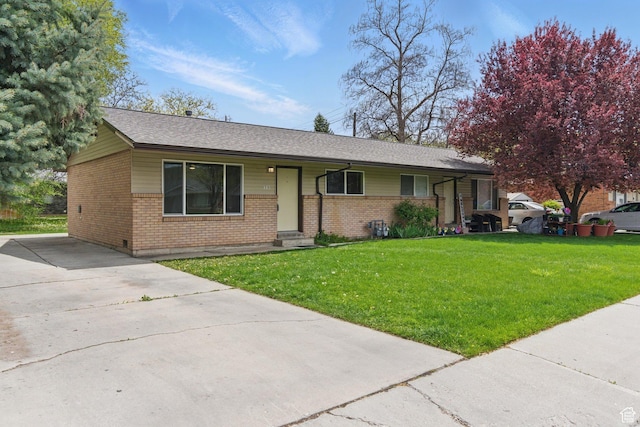 985 S 600 W, Provo, UT 84601 - ranch-style home with a front yard, roof with shingles, concrete driveway, and brick siding