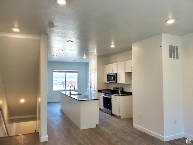 1146 W 310 S, American Fork, UT 84003 - kitchen with wood finished floors, appliances with stainless steel finishes, dark countertops, a sink, and visible vents