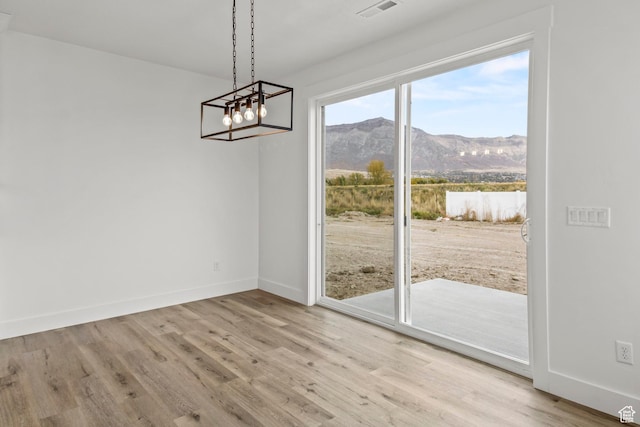 2372 W 2950 N Unit 108, Farr West, UT 84404 - unfurnished dining area with a notable chandelier, a mountain view, visible vents, baseboards, and wood finished floors