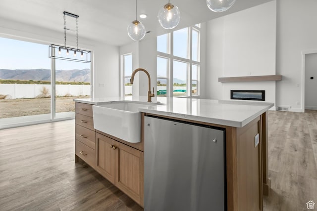 2372 W 2950 N Unit 108, Farr West, UT 84404 - kitchen featuring stainless steel fridge, a glass covered fireplace, light wood-type flooring, a sink, and a center island with sink