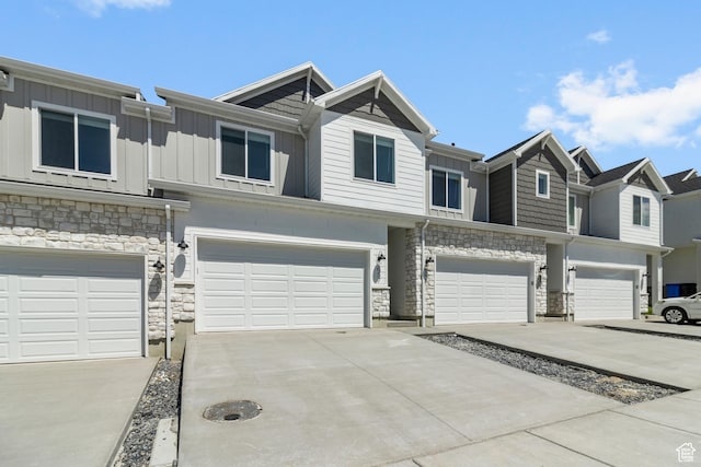 657 W 575 N, Smithfield, UT 84335 - view of property featuring stone siding, an attached garage, board and batten siding, and driveway