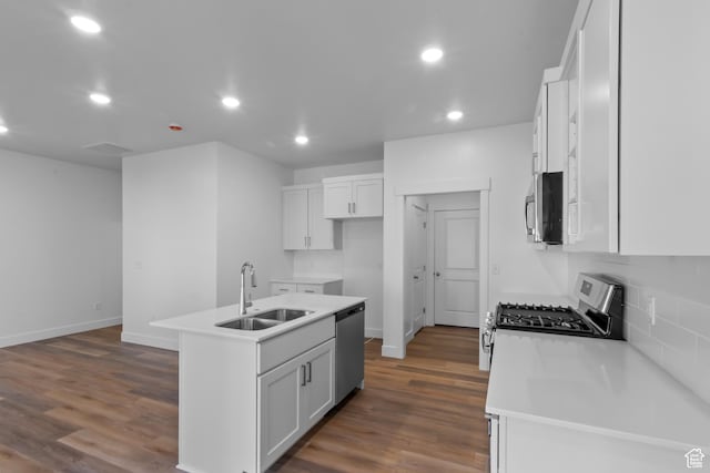 kitchen featuring dark wood finished floors, recessed lighting, stainless steel appliances, and a sink