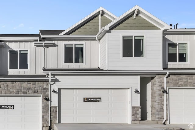 view of front of property featuring a garage, board and batten siding, and stone siding