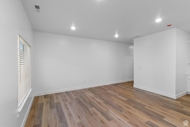 unfurnished room with visible vents, light wood-type flooring, recessed lighting, and baseboards